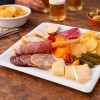 Assiette en carré blanche apéritive entre ami avec chips et charcuterie