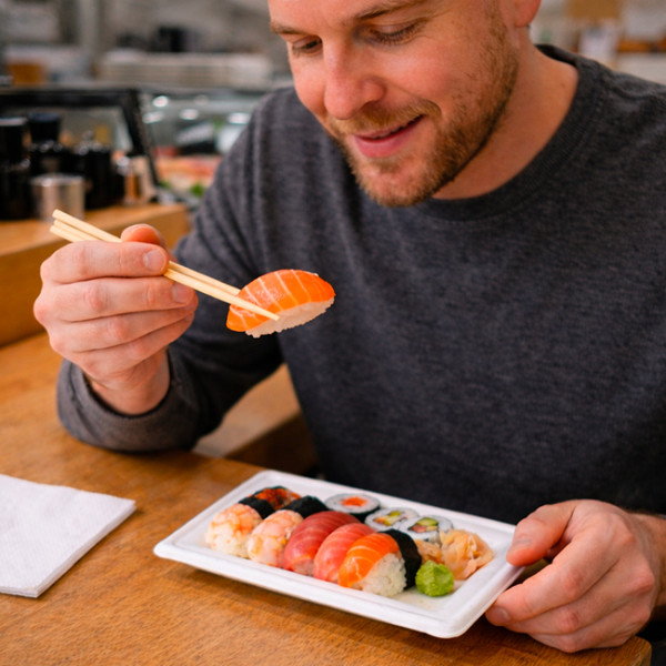 Personne qui déguste des sushis dans un restaurant dans assiette en fibres