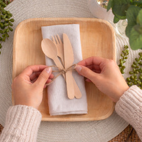 Disposition couvert en bois sur une assiette en palmier