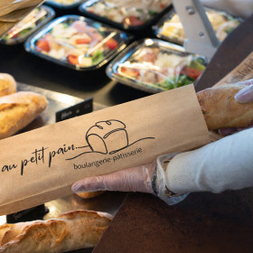 Sac à sandwich personnalisé: vendeuse emballe un sandwich dans une boulangerie